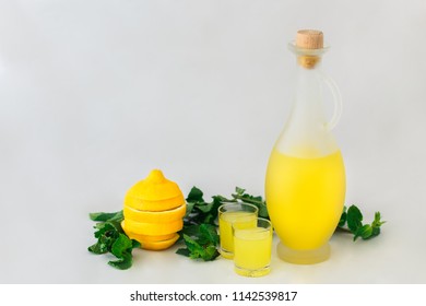 A Bottle Of Limoncello With Glasses, Mint And Lemon Isolated On White