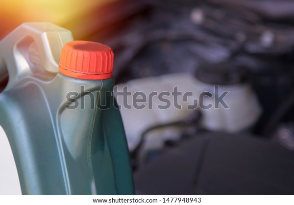 bottle of lubricant or engine oil with the bottom\
of the car engine