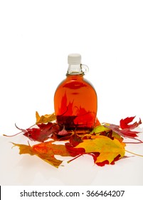 Bottle Of Maple Syrup With Leaves From A Maple Tree.