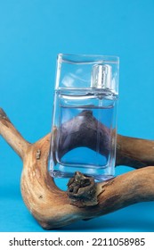 A Bottle Of Men's Cologne On A Branch On A Blue Background. Men's Perfume