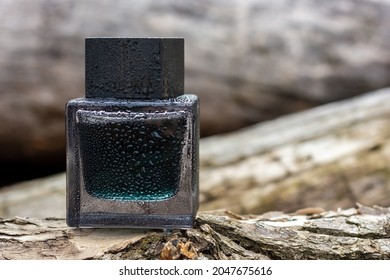 A Bottle Of Men's Perfume On Wooden Logs. A Perfume With A Woody Scent.