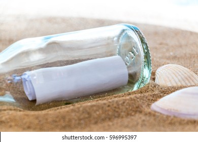 bottle with a message in the sand on the beach. - Shutterstock ID 596995397