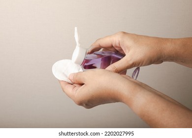 Bottle With Micellar Water And Cotton Pad In Hands. Apply Tonic On A Cotton Pad. Cleanse The Skin From Sebum And Makeup. Composition On A Marble Background. Beauty Concept. Copy Space Text. Flat Lay