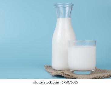 A bottle of milk and glass of milk on a blue background - Shutterstock ID 675076885
