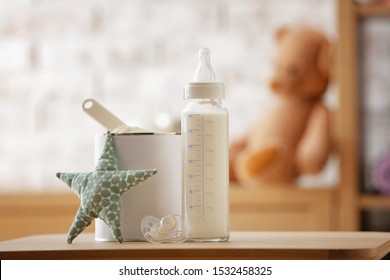 Bottle Of Milk And Jar With Baby Formula On Table In Room