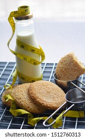 A Bottle Of Milk And Low Calories Sesame Biscuits With Measuring Tape: Healthy Lifestyle Concept (selective Focus Image)