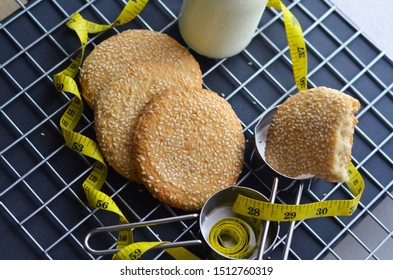 A Bottle Of Milk And Low Calories Sesame Biscuits With Measuring Tape: Healthy Lifestyle Concept (selective Focus Image)