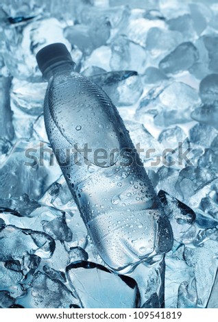 Bottle of mineral water on ice cubes background
