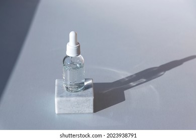 Bottle Of Natural Skincare Lotion On Podium On Light Grey Background With Harsh Shadow. Trendy Selfcare Products.