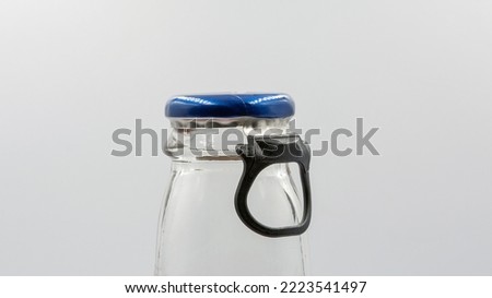 Bottle neck with ring pull cap for opening closeup on white