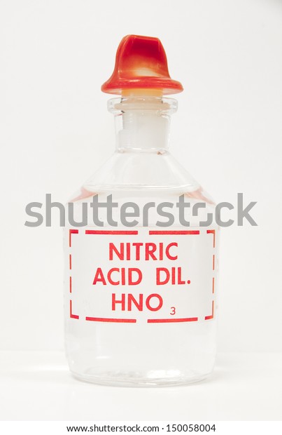 A bottle of nitric acid sits on a laboratory bench.