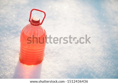 bottle with non-freezing windshield washer fluid, snow background