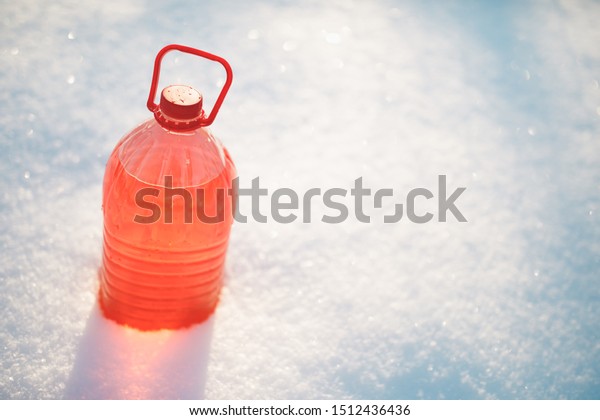 bottle with non-freezing windshield washer\
fluid, snow background