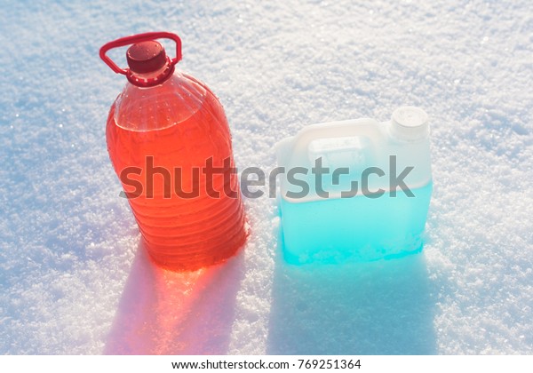 bottle with non-freezing windshield washer
fluid, snow background
