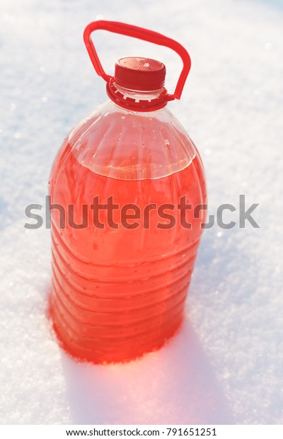 bottle with non-freezing windshield washer\
fluid, snow background