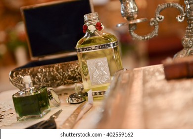 Bottle Of Oil Anointing The Child At Baptism In A Church