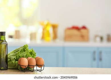 Bottle Of Oil, Lettuce And Eggs On Table In Modern Kitchen