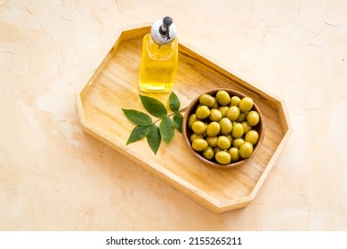 Bottle Of Olive Cooking Oil With Green Olives In Bowl