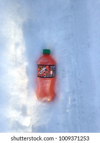 A Bottle Of Orange Crush Soda, Still Containing Product, Is Discarded On A Snowy Street In Nelsonville, Ohio, USA On Jan. 23, 2018.