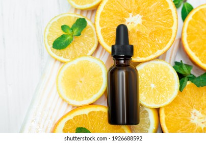 Bottle Of Orange Essential Oil For Aromatherapy. Orange Essential Oil. Citrus Essential Oil On Friut Background