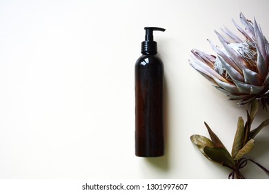 bottle of organic shampoo and protea flower  - Shutterstock ID 1301997607