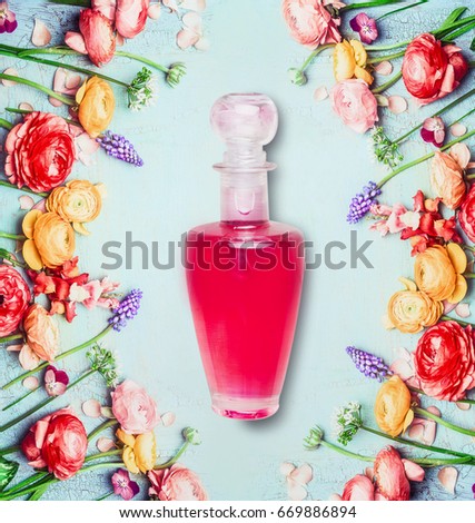 Bottle of perfume or lotion and flowers on shabby chic background, top view. Floral cosmetic product and beauty concept.