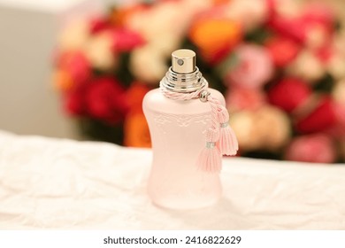 Bottle of perfume on crumpled paper against beautiful roses, closeup - Powered by Shutterstock