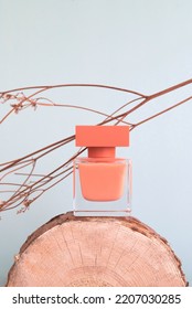 A Bottle Of Perfume Standing On A Log With A Monochromatic Background