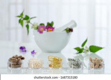 Bottle of pills food suplements healthy medicine medication health care treatment additives pharmacy with ceramic white portar with medicinal fresh plants on background