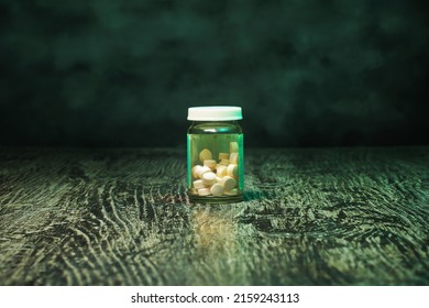 Bottle Of Pills On A Green, Grunge Background. A Social Issues Concept