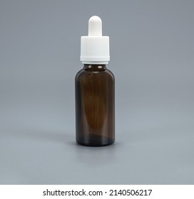 Bottle with pipette glass brown bottle with pipette 30 ml white cap on a light background