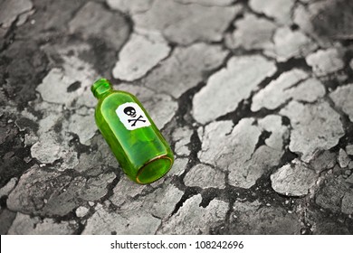 Bottle with the poison lying on poisoned ground