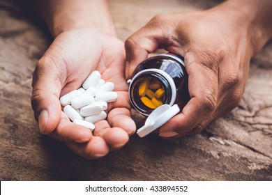 bottle pouring pills on a male's hand