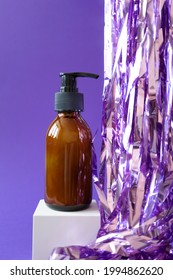 Bottle With Pump For Beauty Product Mockup And Holiday Tinsel On Cube Podium On Violet Background, Vertical