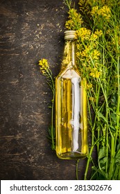 Bottle Of Rape Oil On Rustic Wooden Background, Top View