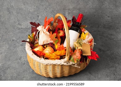 Bottle Of Red Wine With Apples And Cookies In A Gift Basket. Hamper For Autumn Thanksgiving Festival