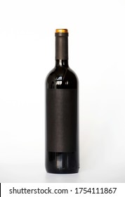 A Bottle Of Red Wine With A Black Label With Empty Glasses