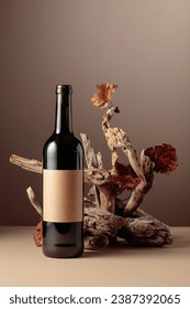 Bottle of red wine with a composition of old wood. Minimalistic composition on a beige background for product branding, identity, and packaging. Copy space.