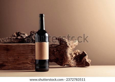 Bottle of red wine with an old empty label on a beige background. Copy space.
