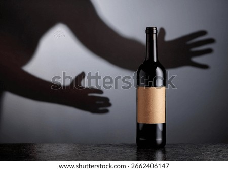 Bottle of red wine with old empty label. Hand in reaches for a bottle of red wine. Copy space.