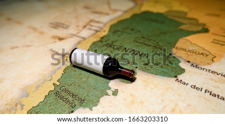 A bottle of red wine on a map of Argentina.