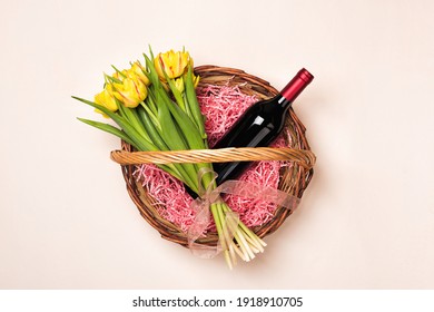 Bottle of red wine and tulip flowers in gift basket for Women's day and month, Mother's Day, birthday