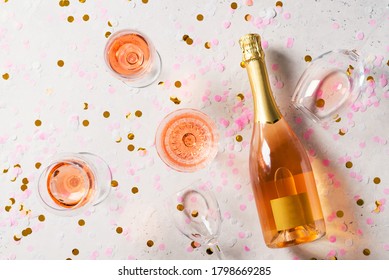 Bottle Of Rose Sparkling Wine Or Champagne With Crystal Wineglass On White Or Light  Grey Background, Top View, Copy Space