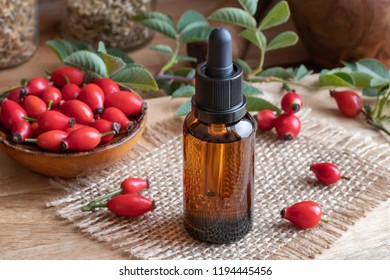 A Bottle Of Rosehip Seed Oil With Fresh Hips