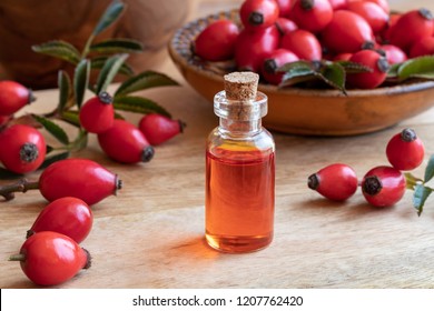 A Bottle Of Rosehip Seed Oil With Fresh Fruit