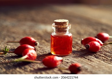 A Bottle Of Rosehip Seed Oil With Fresh Berries