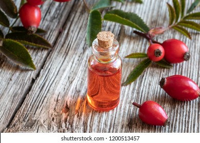 A Bottle Of Rosehip Seed Oil With Ripe Berries