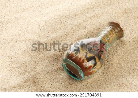 Bottle with sand picture on sand background