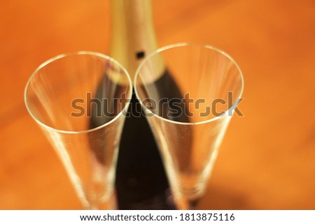 Bottle of shampagne and a two empty glasses before drinking on the wooden background