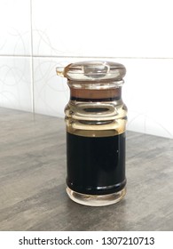 A bottle of soysauce on a table inside a restaurant